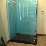 Frameless custom shower enclosure with chrome accents and clear glass